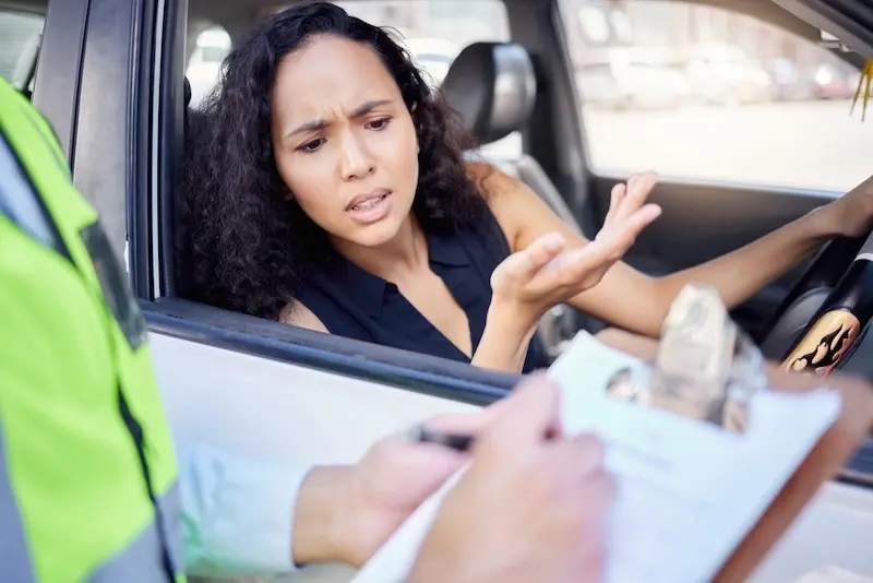 A driver argues with a police officer who is ordering a field sobriety test by the roadside.