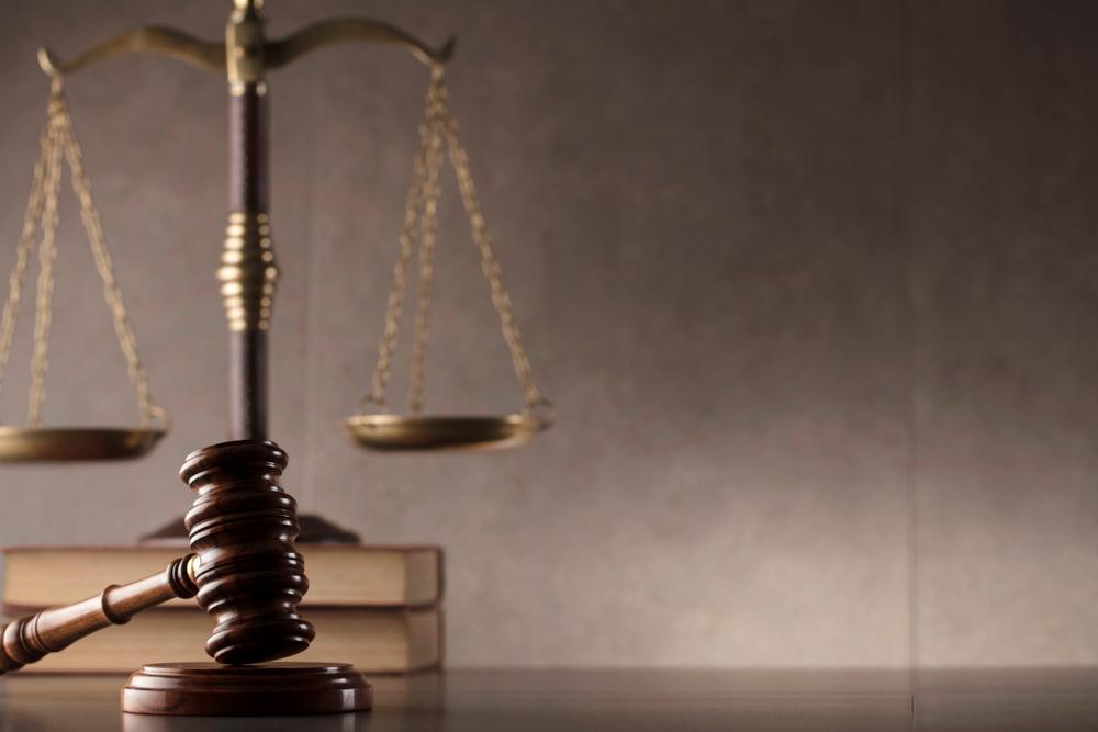 An image of books, a gavel, and the scales of justice—the kinds of items that you might see in a courtroom as you learn the answer to the question, “What is a sex crime?