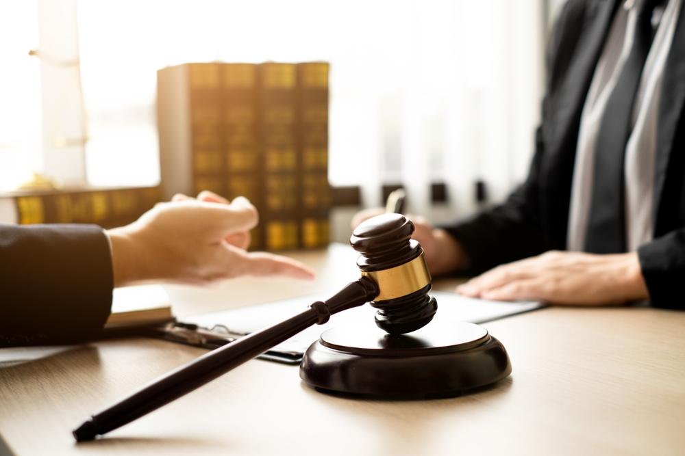 An attorney and client consult on a case while the client wonders how to find a good criminal defense lawyer.